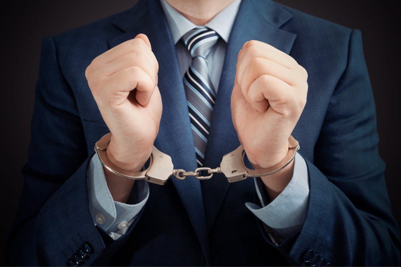 businessman's hands in handcuffs