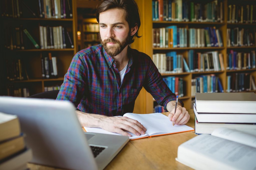 male student studying in library
