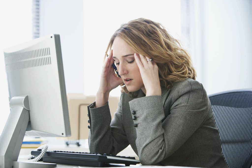 young, stressed female lawyer rubbing her head with eyes closed