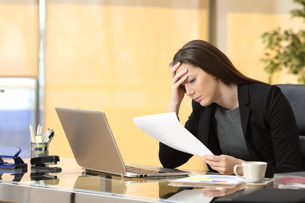 Businesswoman stares at a legal document as she contemplates her legal difficulties