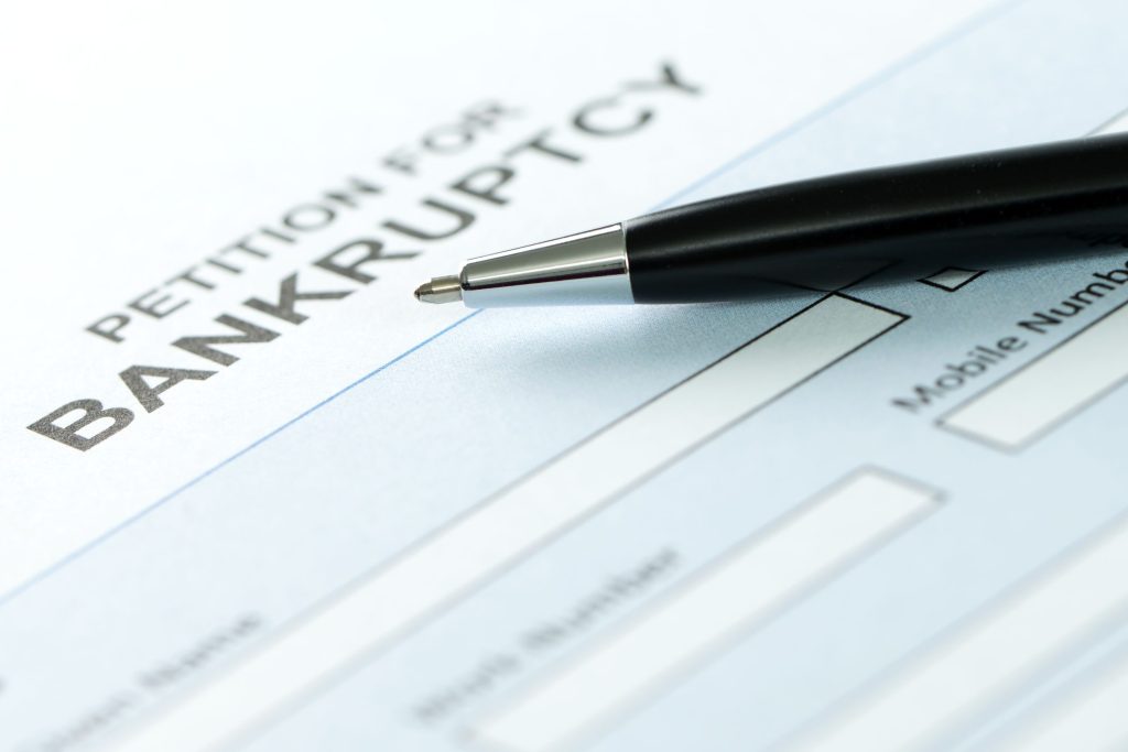 A pen rests on top of a petition for bankruptcy document.