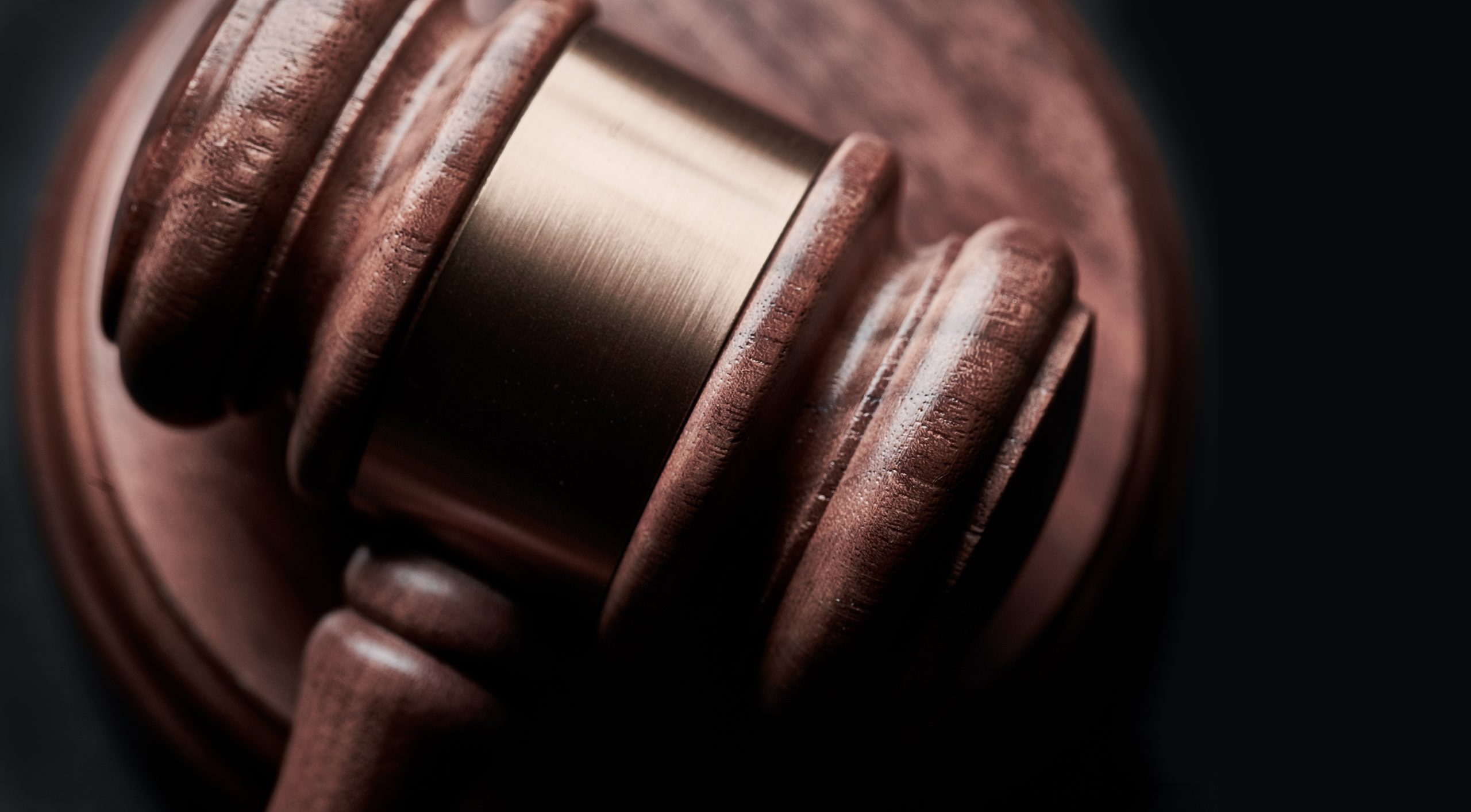A close-up image of a gavel and block sitting on a table