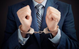 businessman's hands in handcuffs