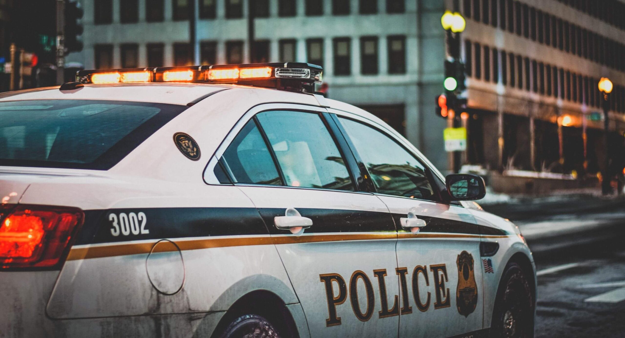 Police car pulls up to the scene of a crime in a metropolitan city