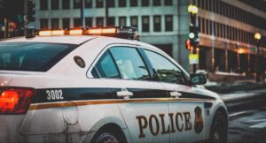 A police car with its lights on driving through a city