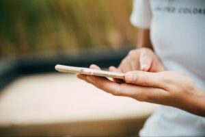 Hands holding a phone with a blurred background