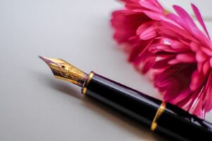 A fountain pen next to flowers on wills and trusts